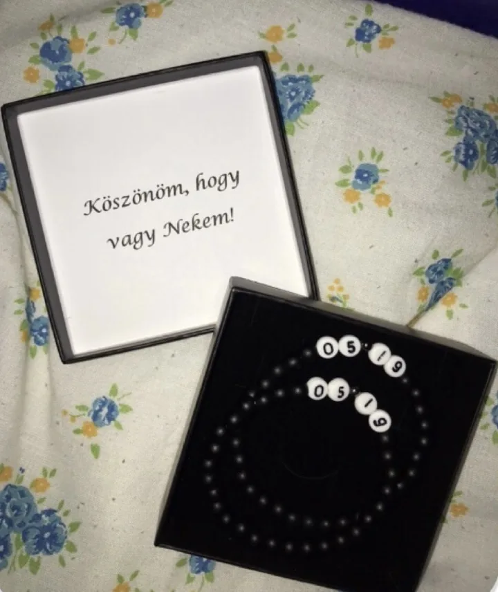 Betűs fekete karkötő díszdobozban, vásárlói fotón.
